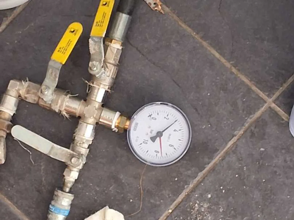 pressure test manifold and gauge set up on hallway floor during leak detection