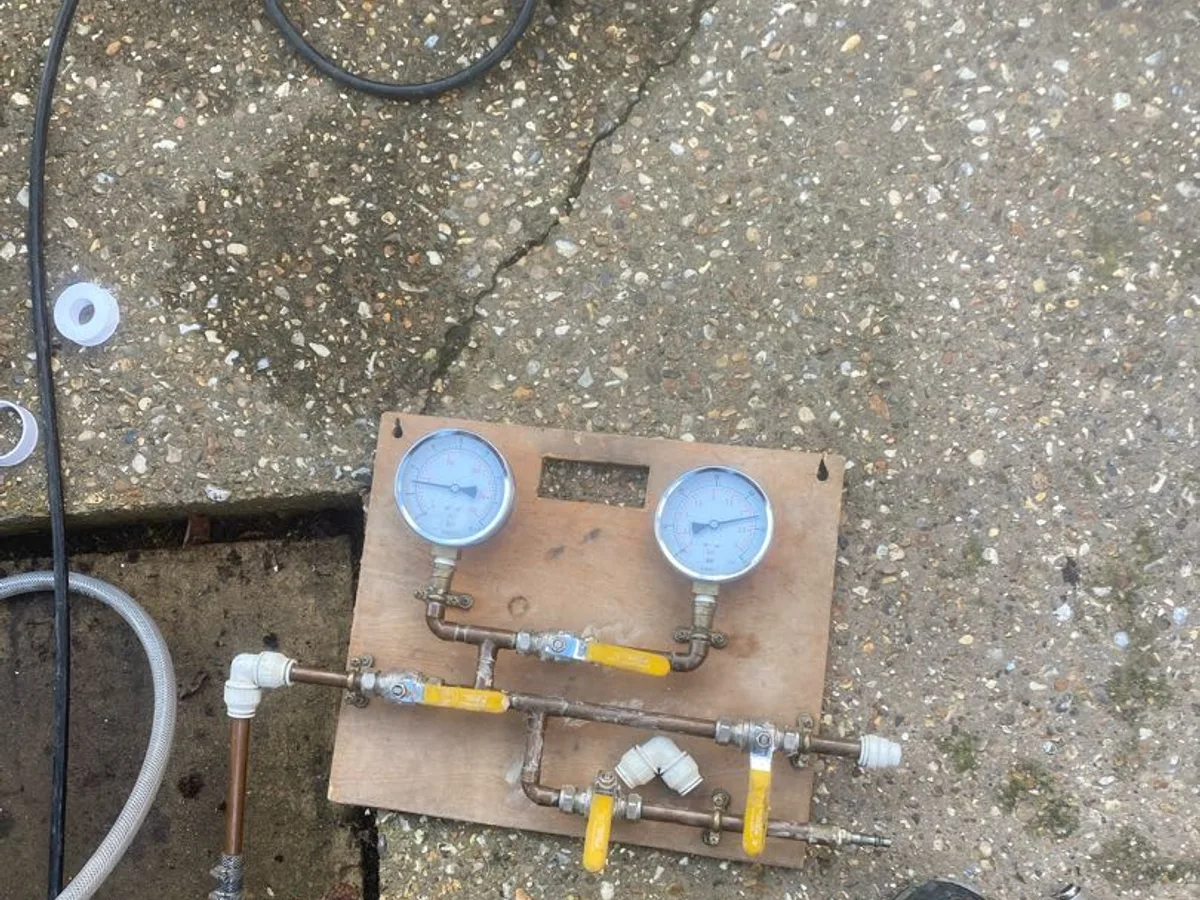 dual-gauge pressure testing rig connected to internal pipework during leak detection survey