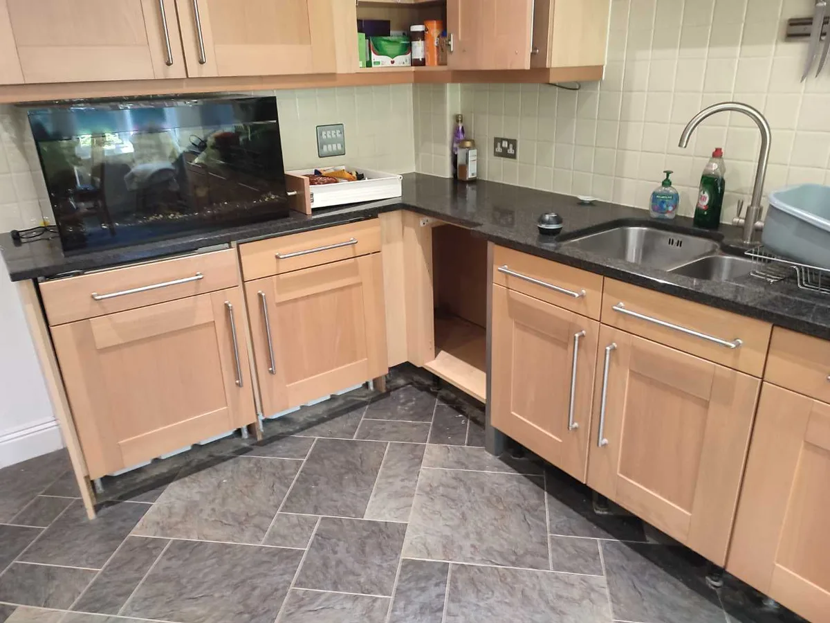 corner kitchen unit with door removed showing damage before leak detection works started