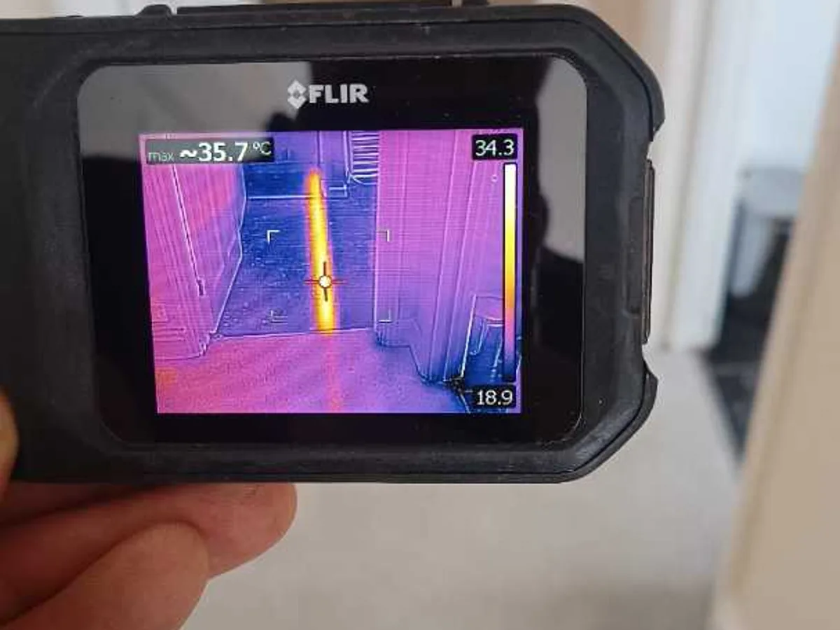thermal imaging camera screen showing hot pipe run in corridor during leak detection
