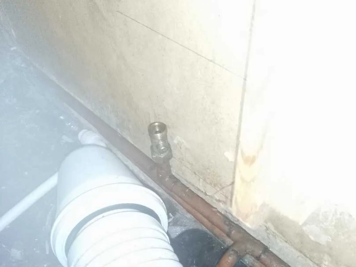 leak located at open-ended copper pipe beneath bath alongside drainage pipework