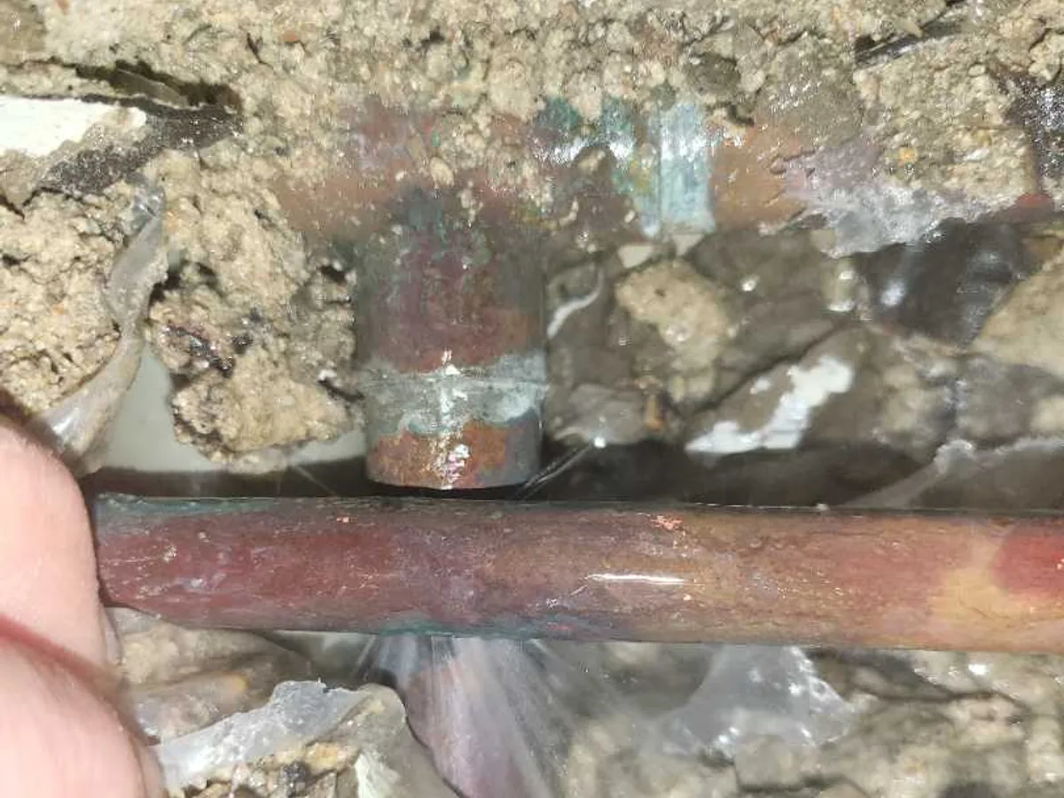 leak located at corroded and perforated 15mm copper hot supply joint in wet kitchen screed