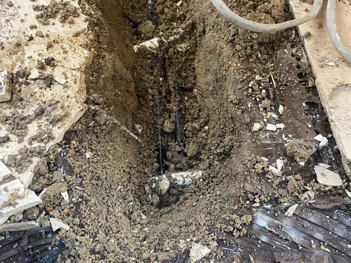 leak located at buried pipe exposed in wet screed trench beneath kitchen floor