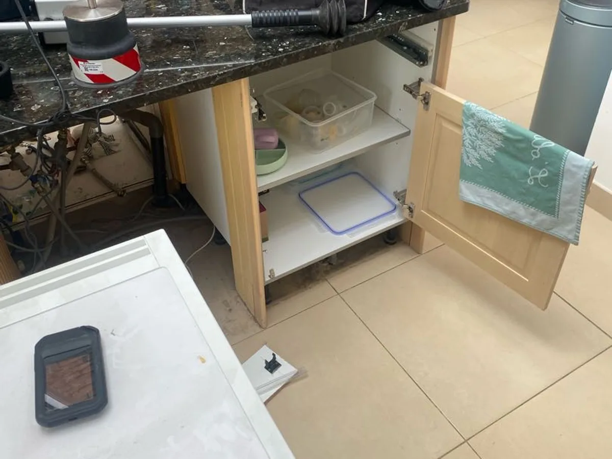 kitchen island unit opened and equipment laid out on worktop during leak detection investigation