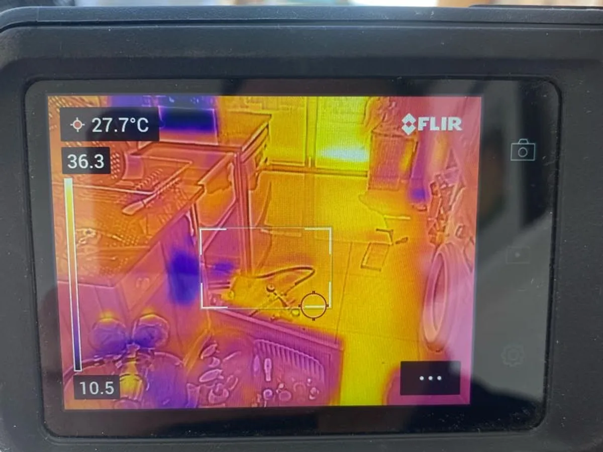 thermal imaging camera screen showing heat signature on kitchen floor during leak detection