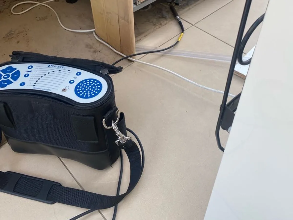 tracer gas detection unit placed on kitchen floor beneath units during leak detection survey