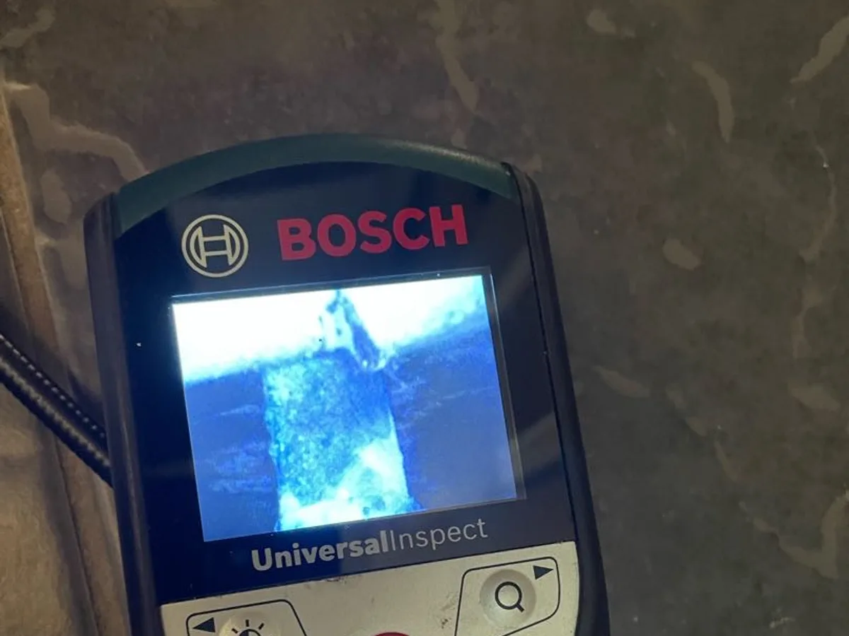 endoscopic camera screen showing corrosion residue on copper pipe during investigation — during leak detection