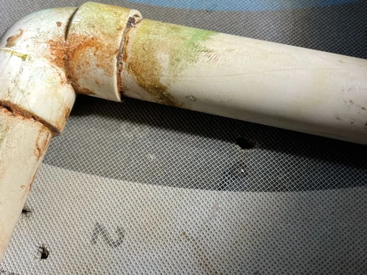 leak found at failed condensate pipe elbow with silt staining and deterioration visible