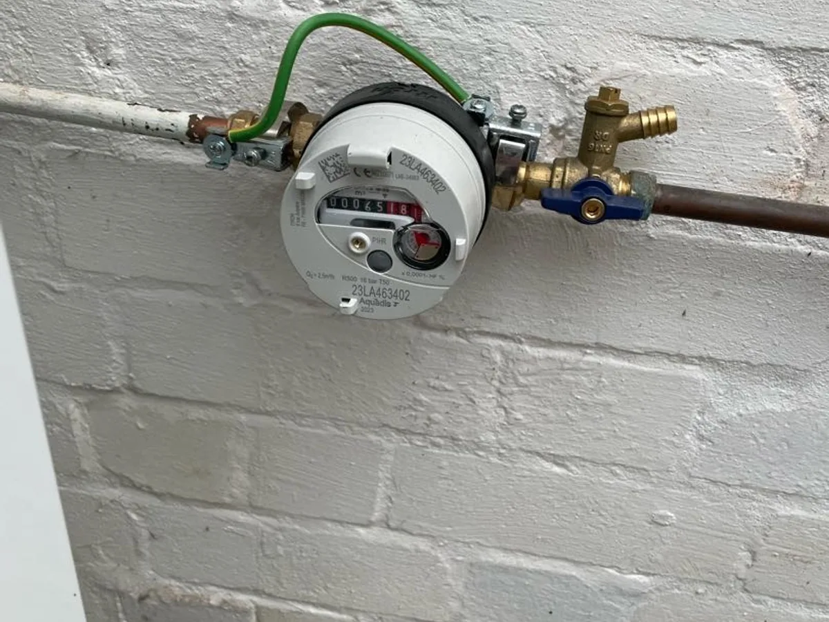 water meter on external wall being observed during leak detection