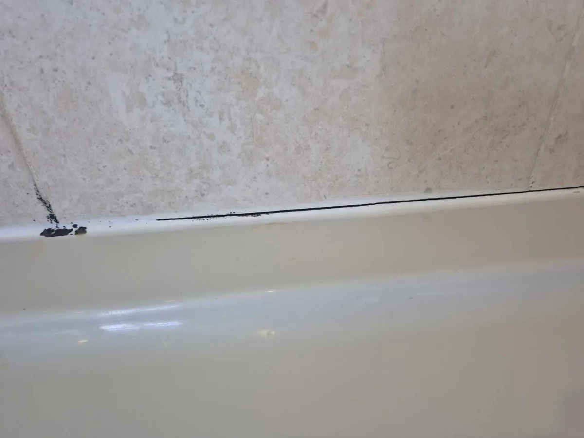 mouldy gap between bath rim and wall tiles at initial inspection before works