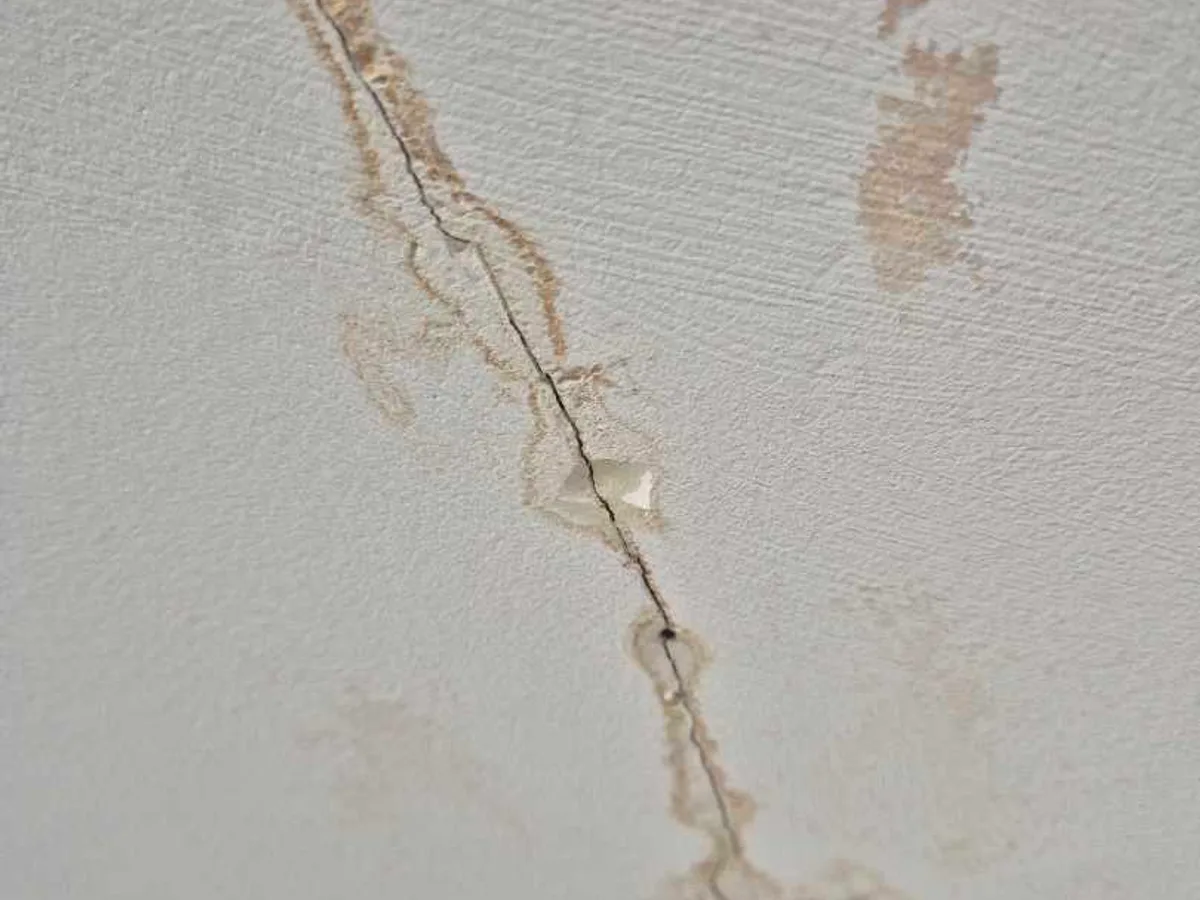 close-up of water-stained ceiling crack with tide marks before works started