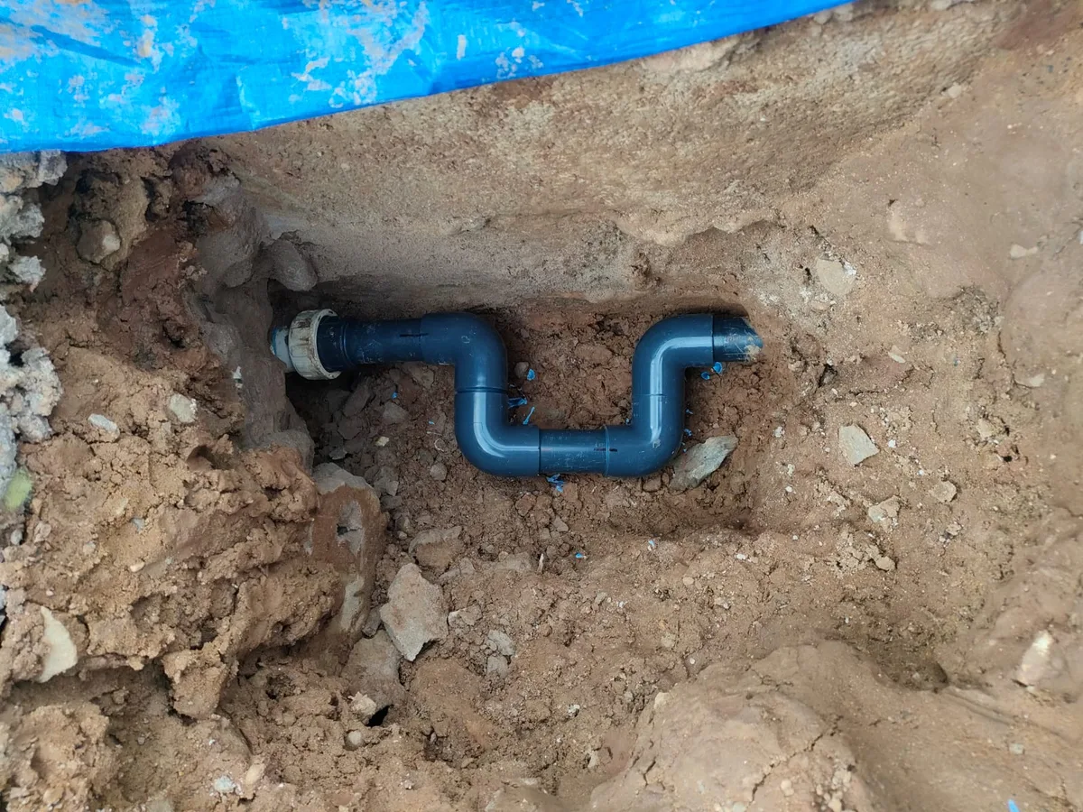 repair in progress with new uPVC pipe bypass fitted to skimmer line in excavated trench