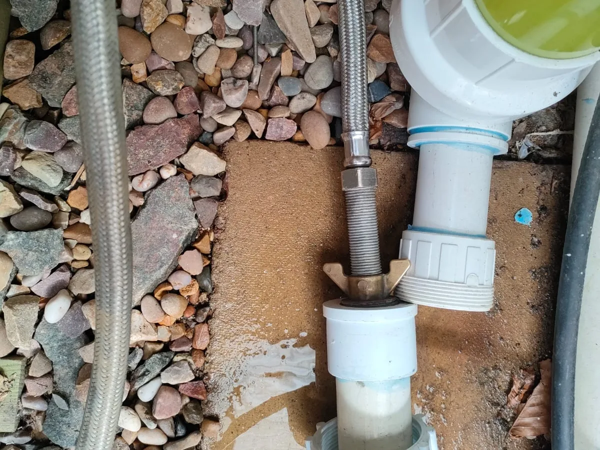 leak exposed at skimmer union fitting with wet gravel surround at pool plant area — leak located at