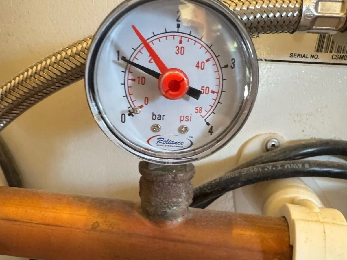 pressure gauge on hot water supply pipe during leak detection investigation