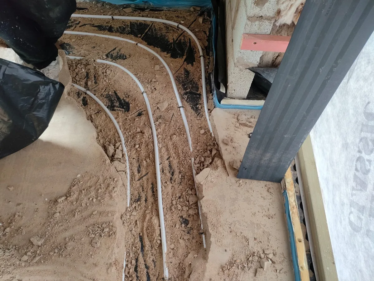 leak exposed at underfloor heating pipe runs beneath broken concrete screed — leak located at