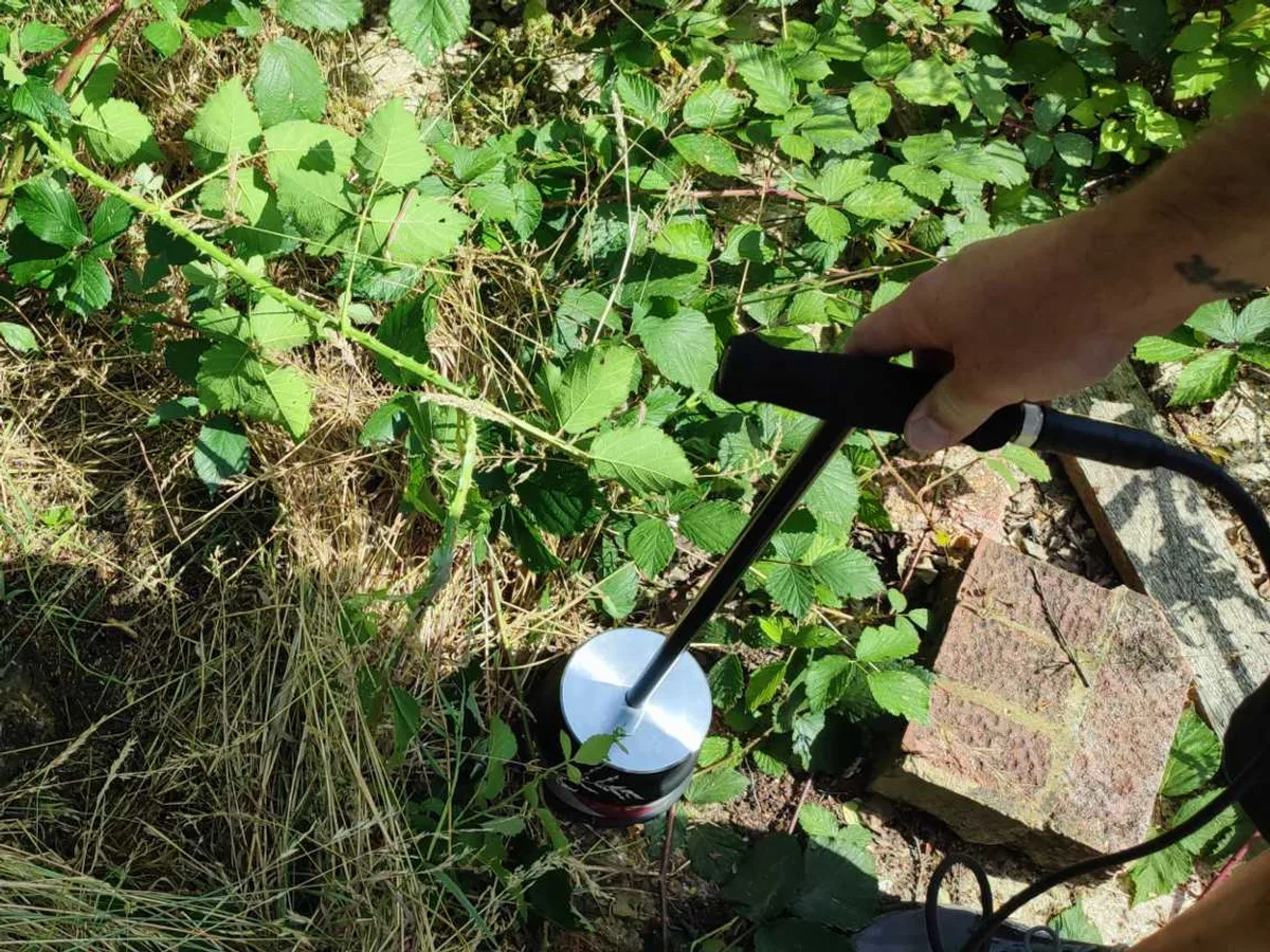 acoustic listening probe pressed into overgrown ground during leak detection