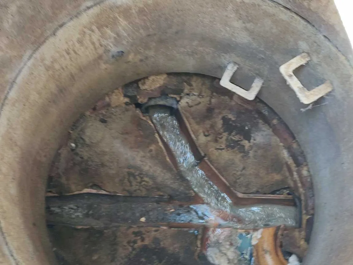 interior of drain inspection chamber examined during leak detection survey