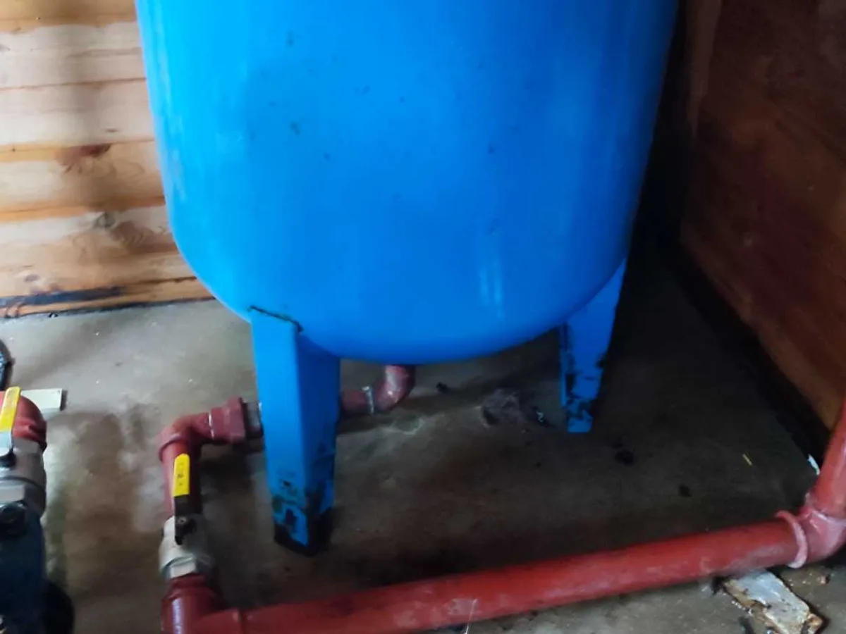blue expansion vessel and red pump pipework in pump room before leak detection works