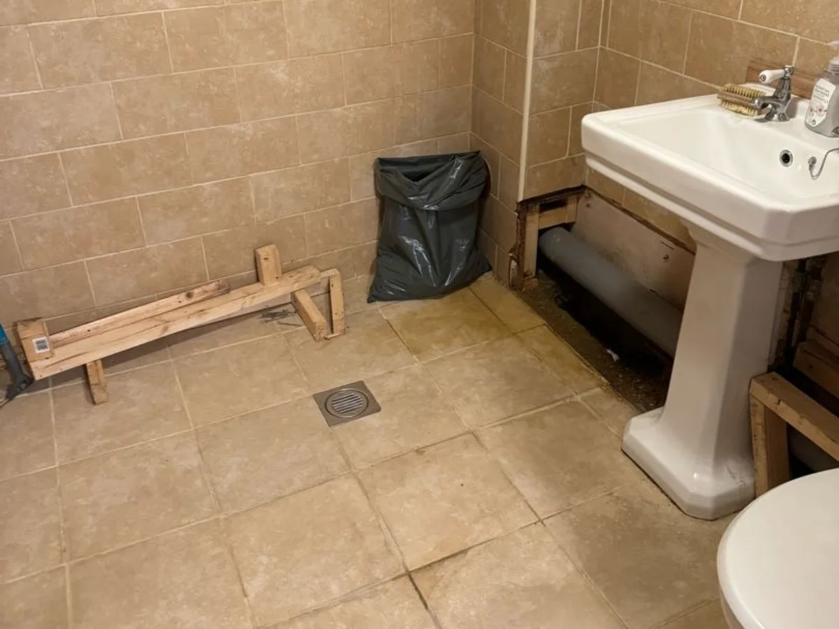 bathroom area reinstated after repair with boxing removed and floor cleared following works completed