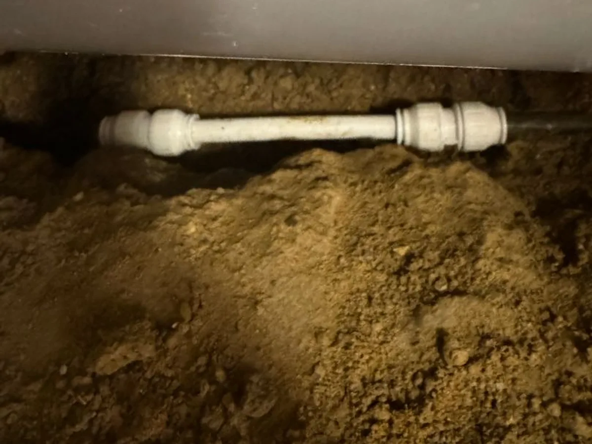 new 15mm plastic pipe with push-fit fittings installed as repair completed beneath concrete floor