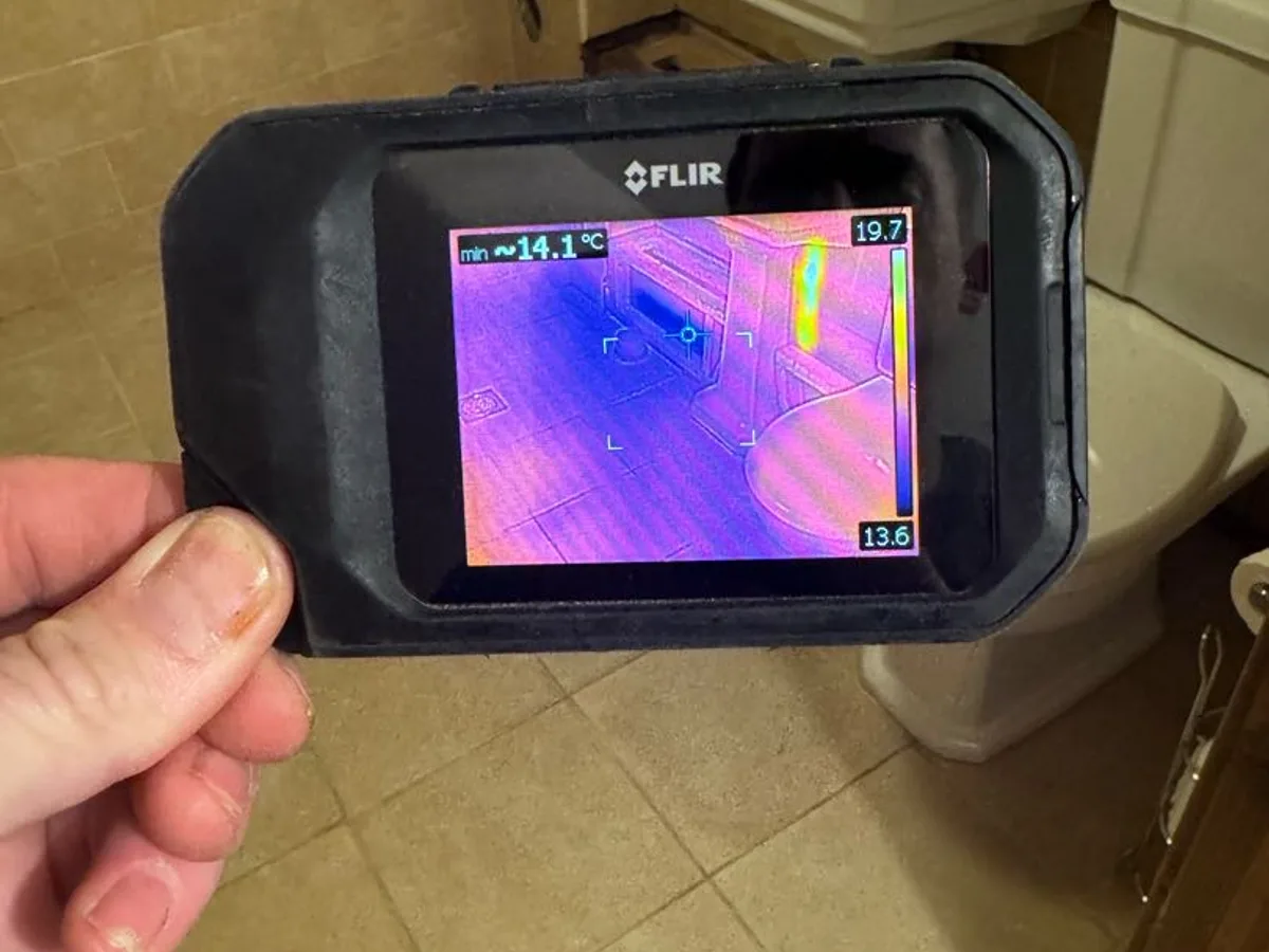 thermal imaging camera screen showing cold patch on bathroom floor during leak detection survey