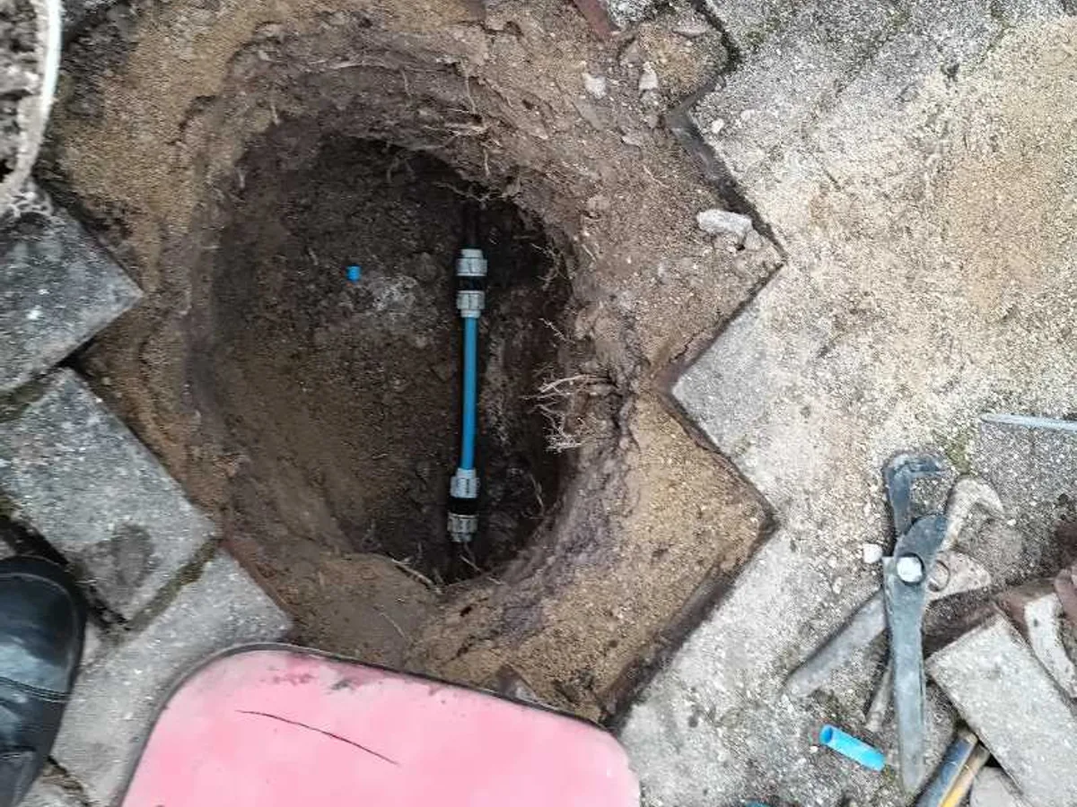 20mm MDPE replacement pipe with push-fit fittings in driveway excavation repair in progress
