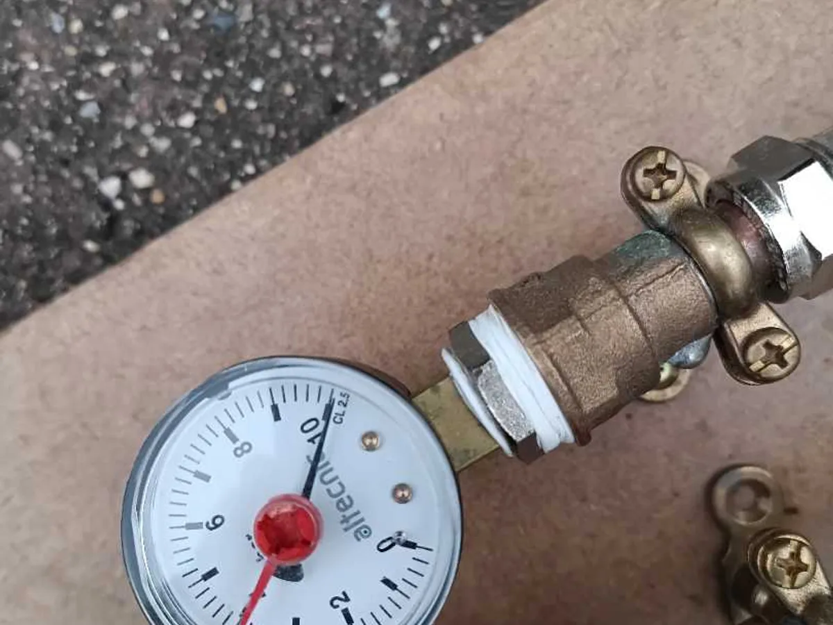pressure gauge reading near zero on test rig confirming integrity during post-repair pressure test — during leak detection