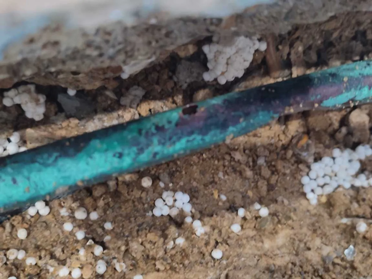 leak identified at heavily corroded 15mm copper pipe surface exposed in screed