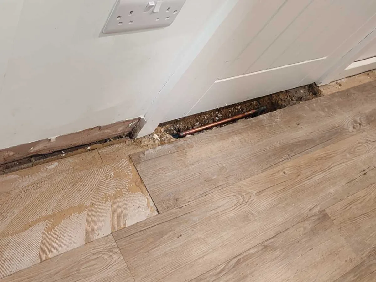 utility room floor with open trench and replaced pipe after works completed
