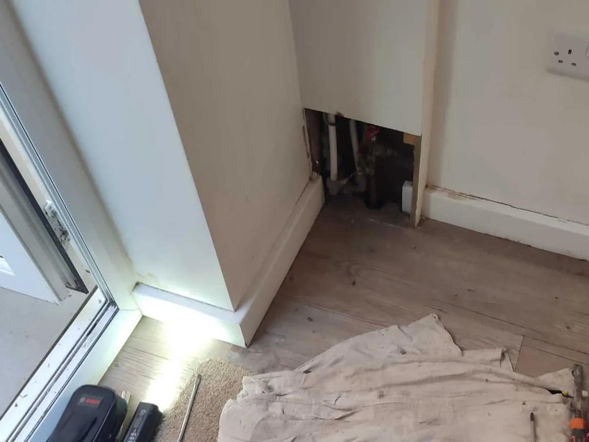 utility room floor opened up with pipework exposed during repair in progress