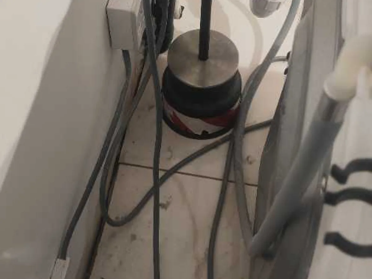 ground microphone positioned on utility room floor tiles during leak detection survey