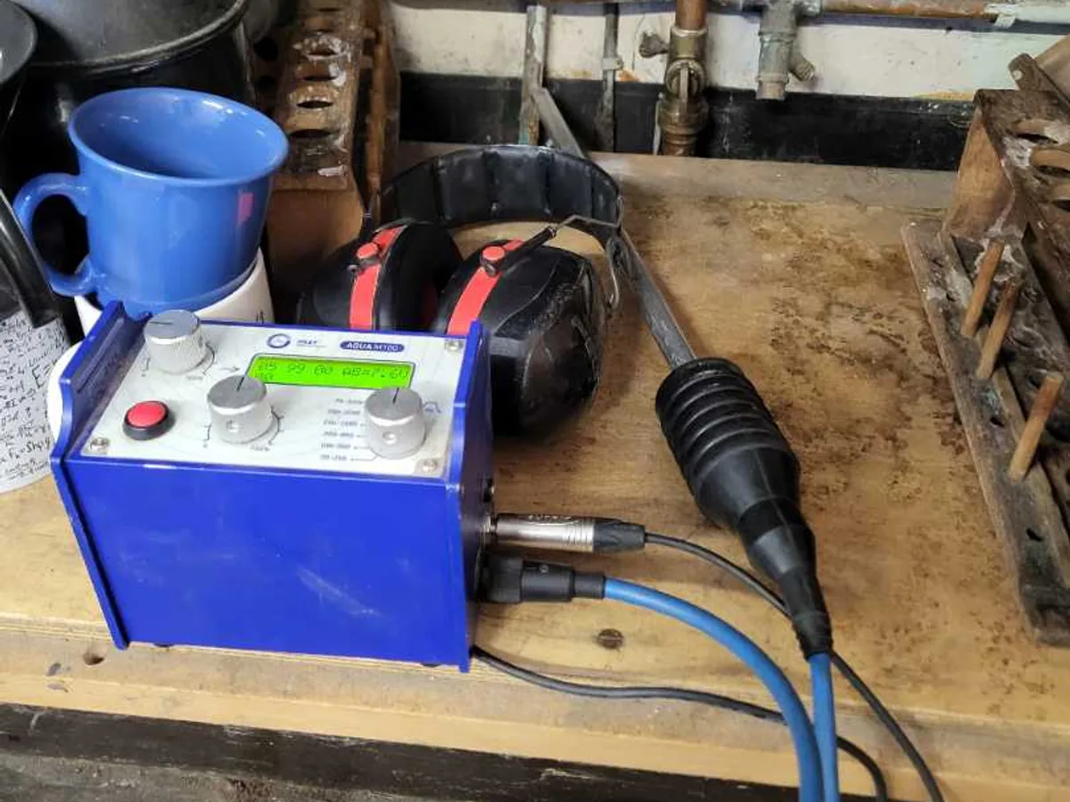 acoustic leak detection unit with headphones and ground microphone in use during leak detection