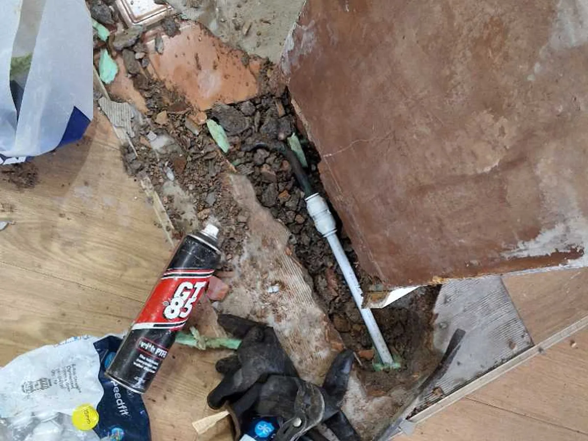 leak located at 15mm cold mains pipe exposed in concrete screed excavation beneath kitchen wall