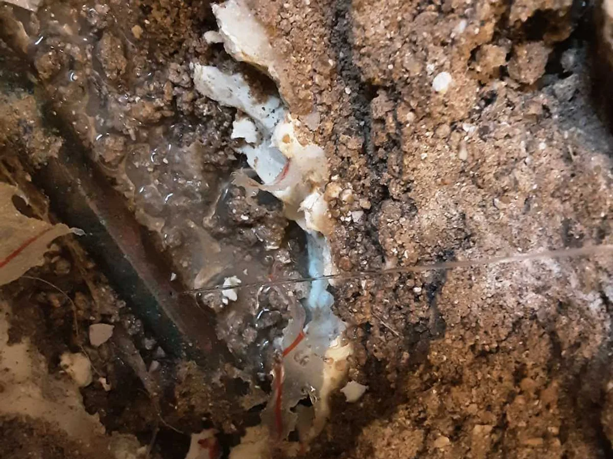 leak located at pinhole in 15mm copper supply pipe exposed beneath ground floor WC tiles