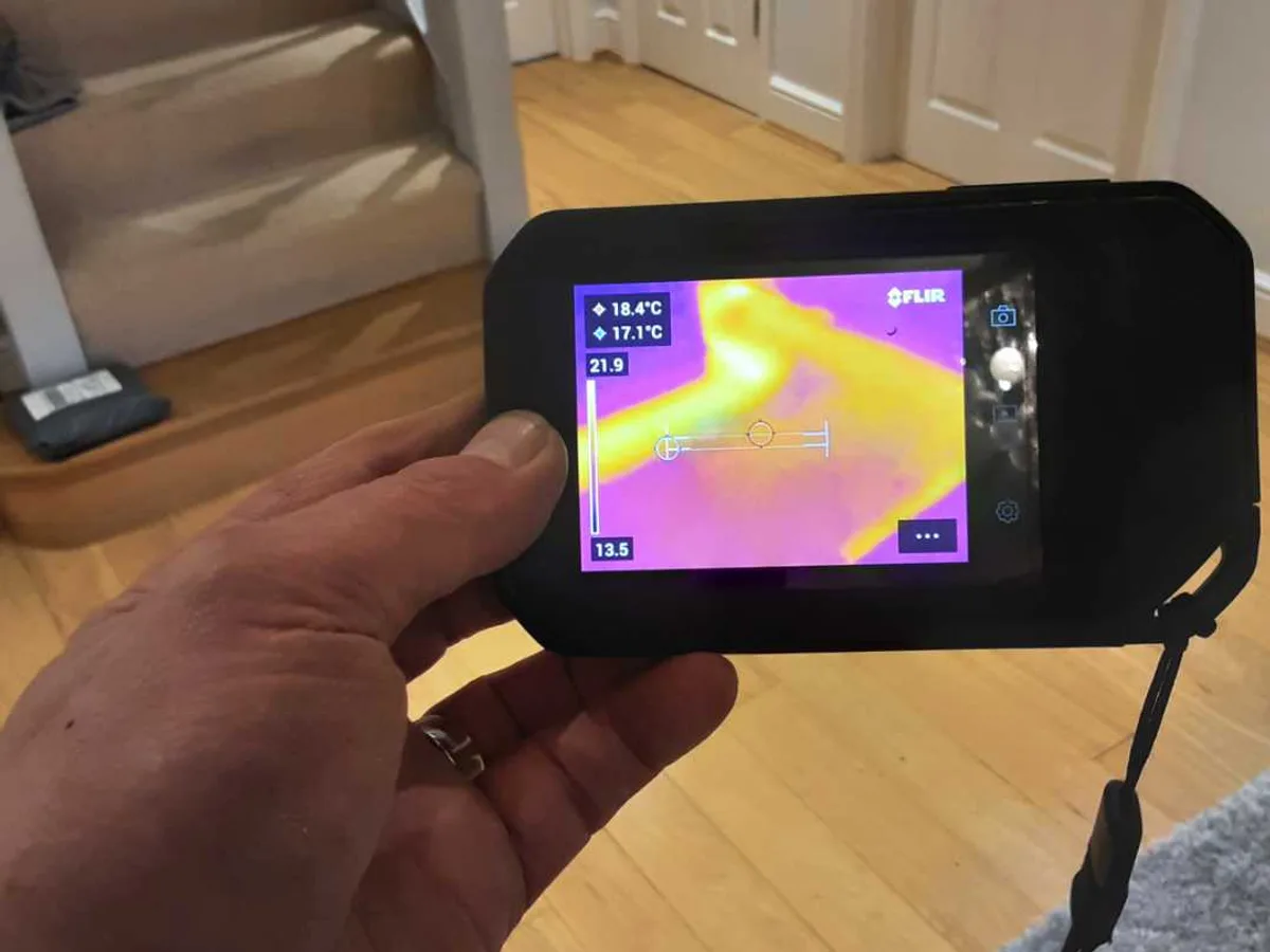 thermal imaging camera displaying warm pipe signature in hallway floor during leak detection