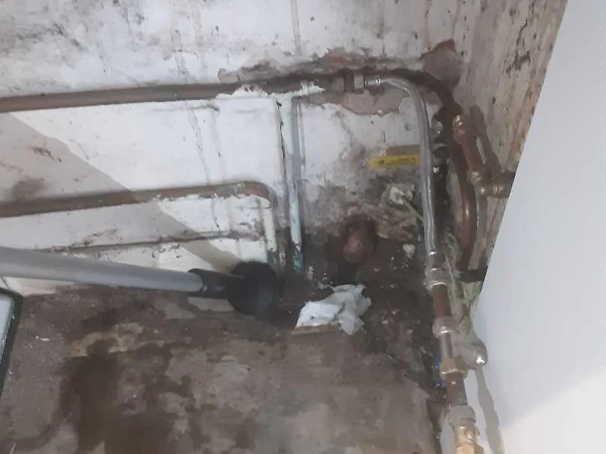fault exposed at wet copper pipework beneath fixed fridge after concrete floor removed