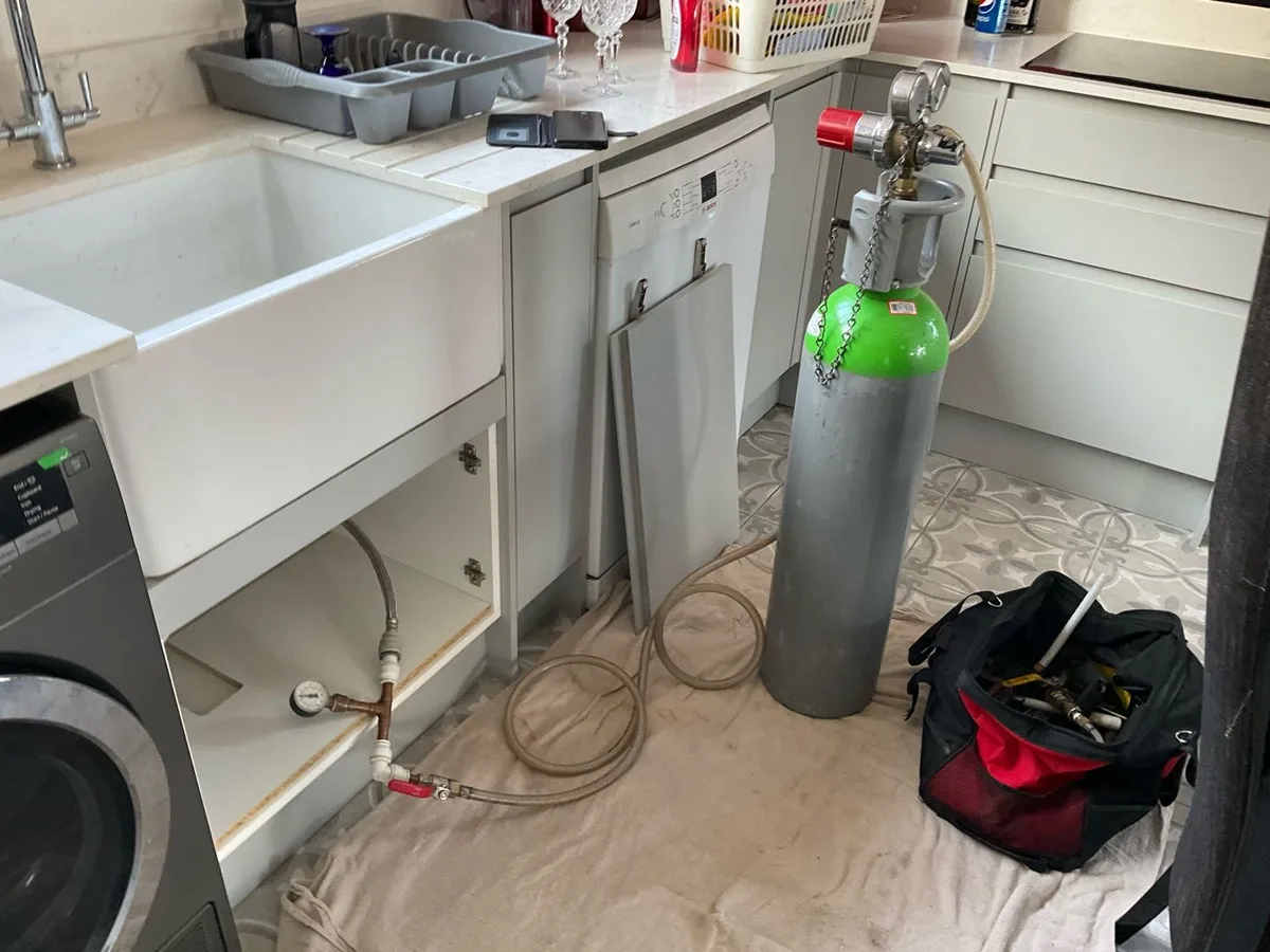 hydrogen tracer gas cylinder connected to kitchen supply pipework during leak detection