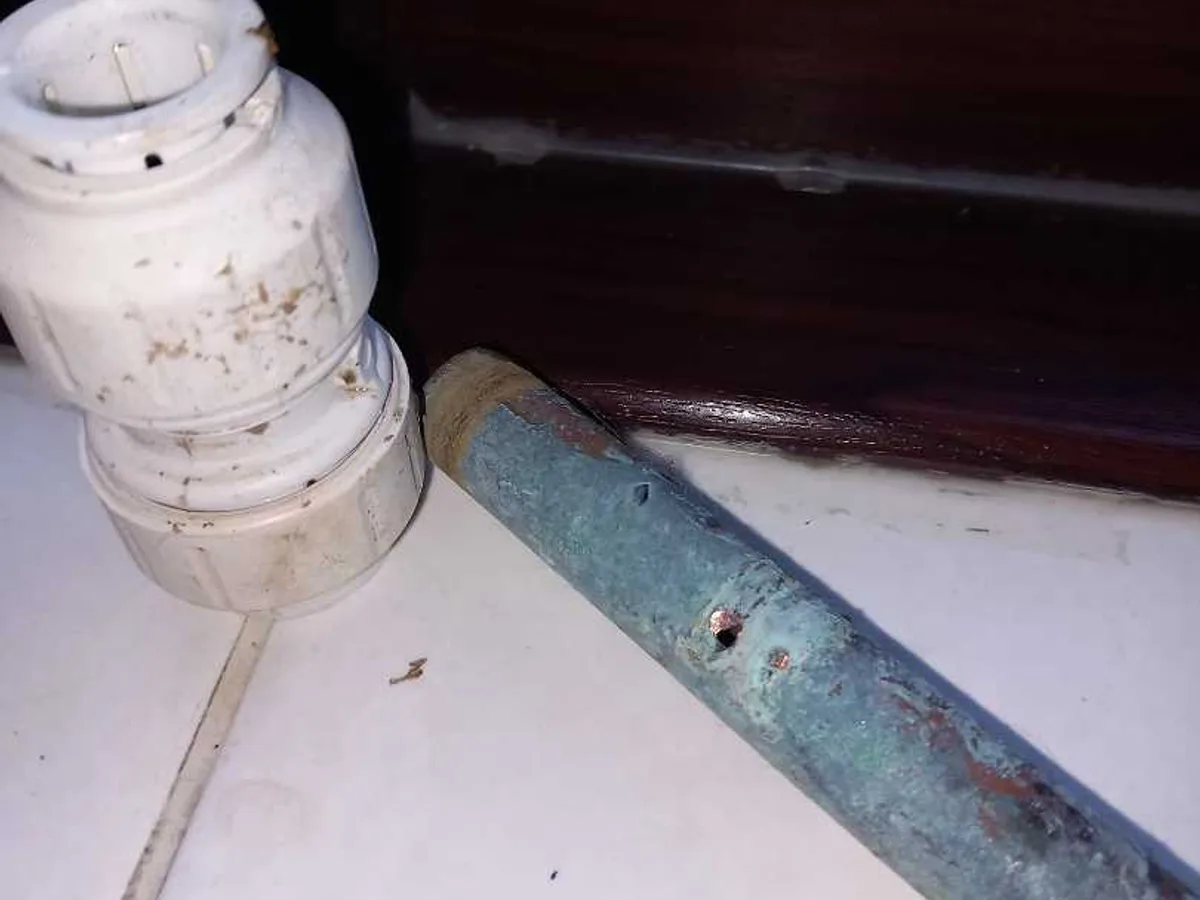 fault identified at corroded copper pipe with push-fit connector removed showing pinhole damage — leak located at
