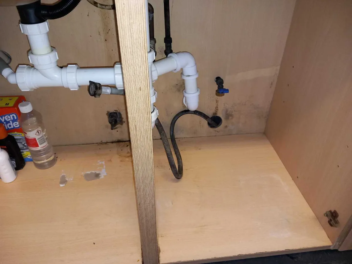 repair completed under kitchen sink cabinet with replaced pipework and fittings reinstalled