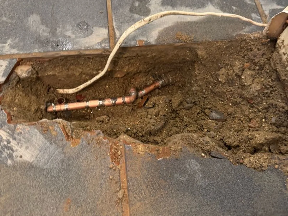 leak exposed at copper pipework buried beneath kitchen floor after tile removal — leak located at