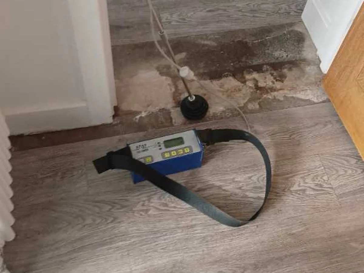 acoustic listening equipment placed on damp kitchen doorway floor during leak detection