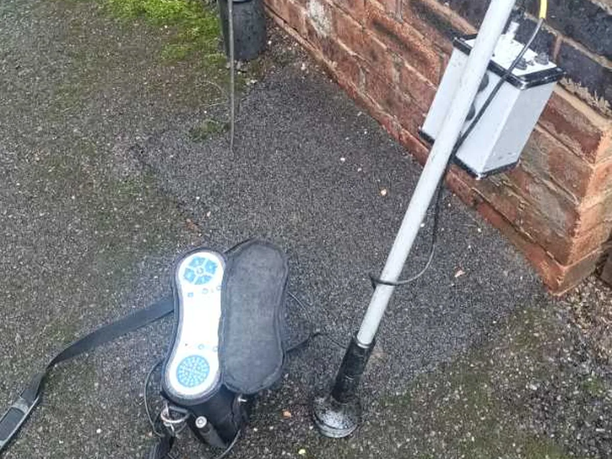 acoustic listening device and gas detector resting against brick wall during leak detection