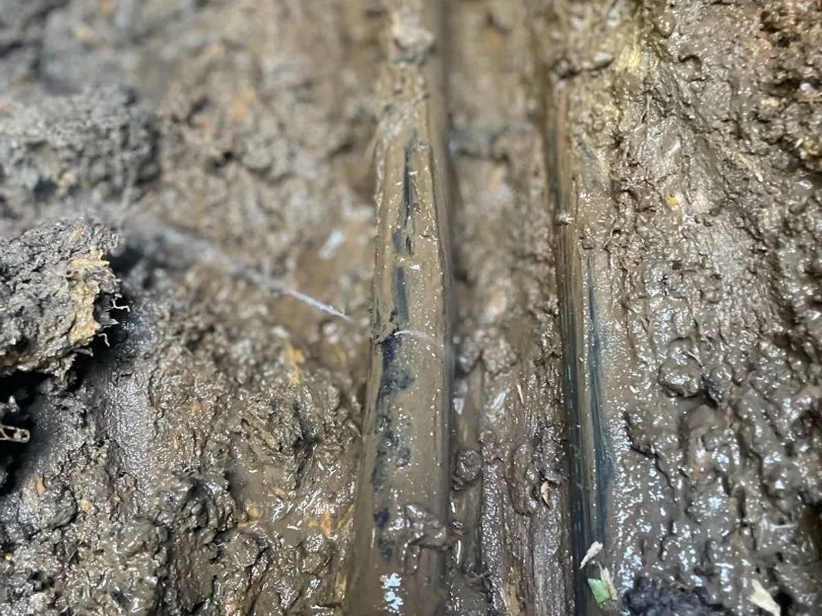 leak located at split in black poly mains pipe with water streaming from fault