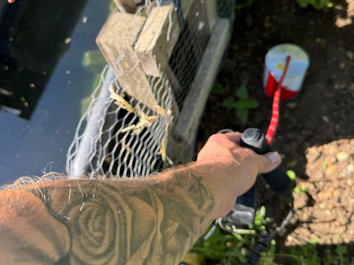 engineer holding gas detection unit near allotment standpipe during leak detection