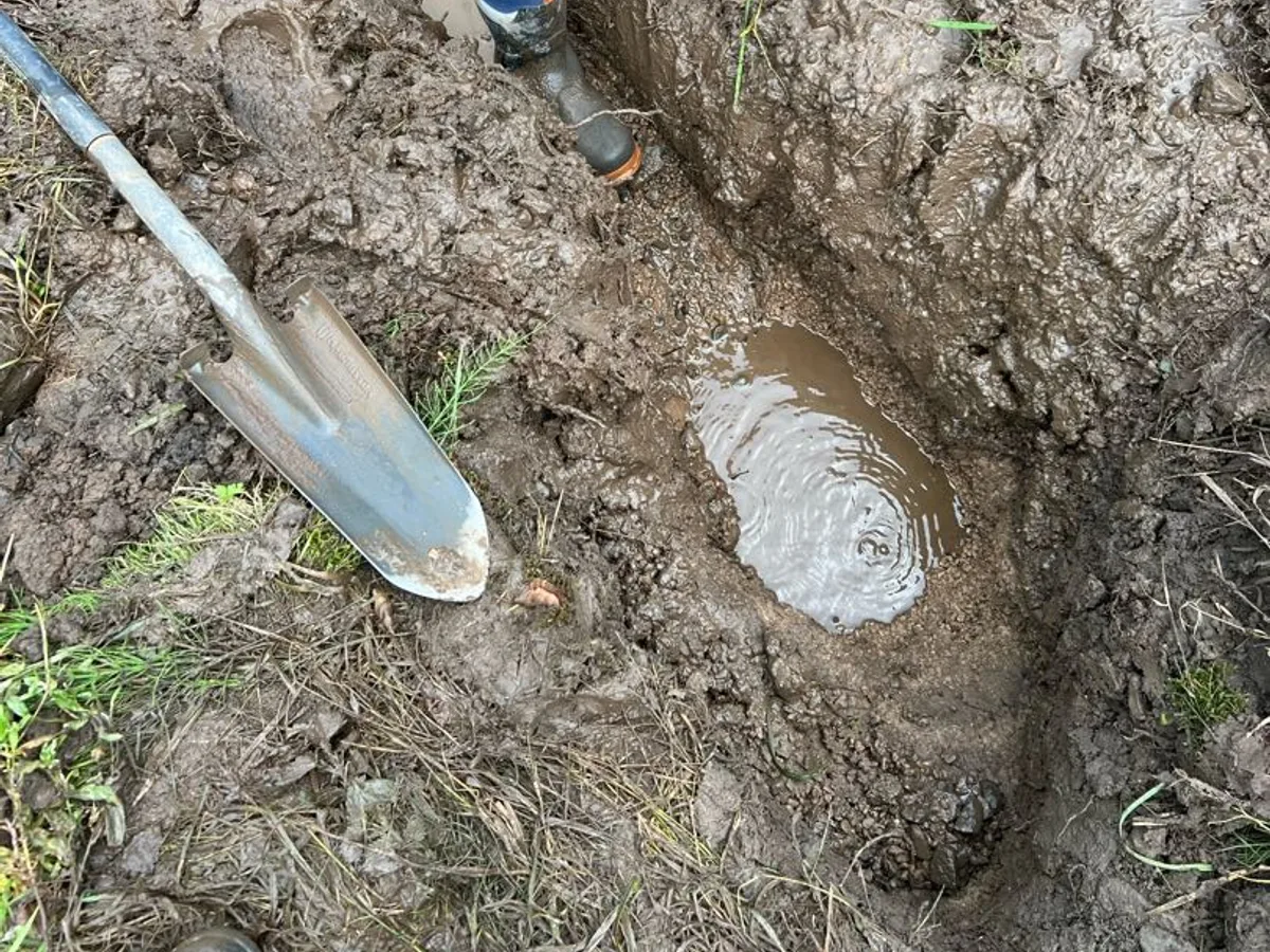leak located at waterlogged excavation trench with pooling water around buried pipework