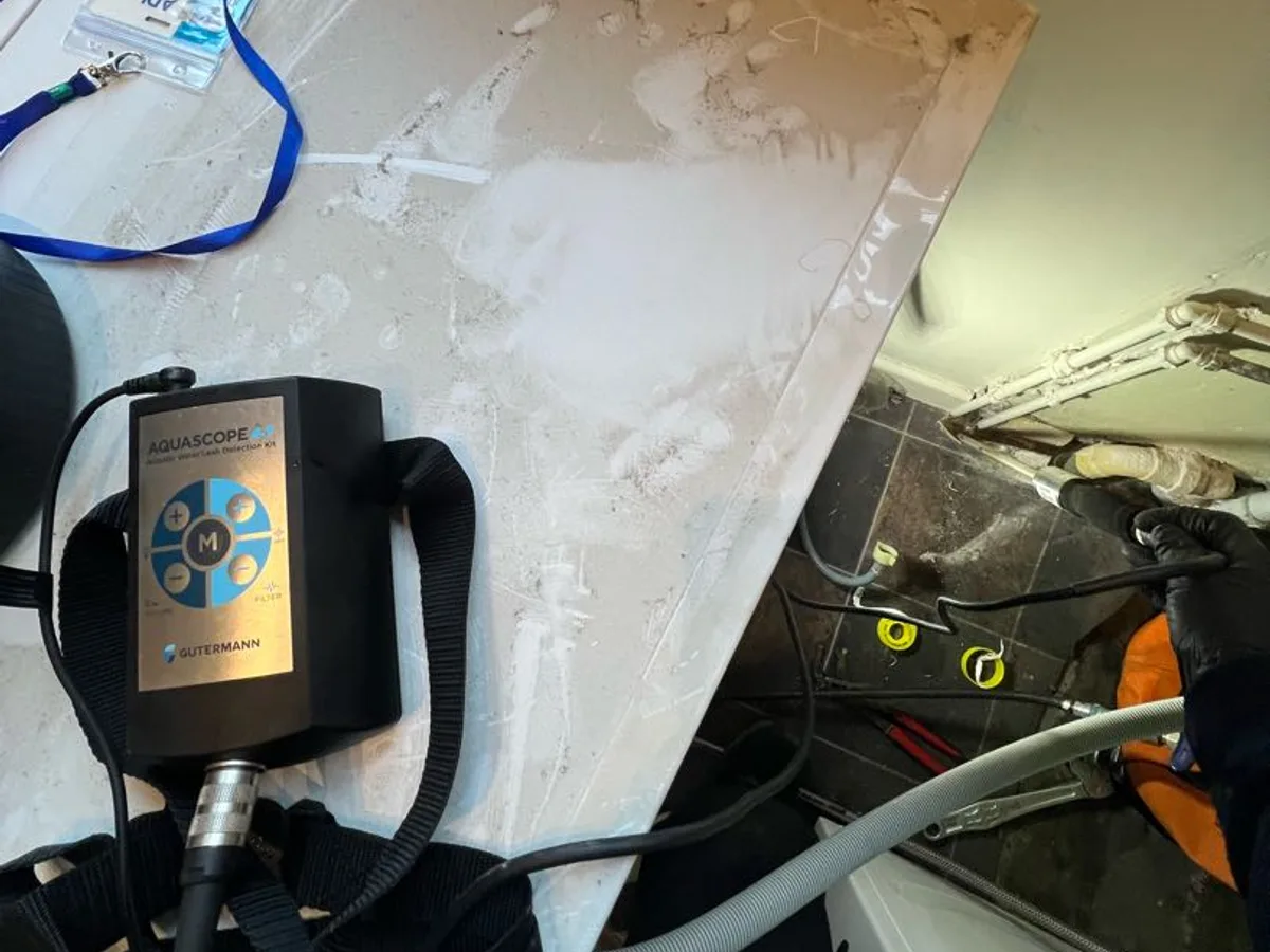 acoustic correlator unit placed on kitchen floor panel during leak detection survey