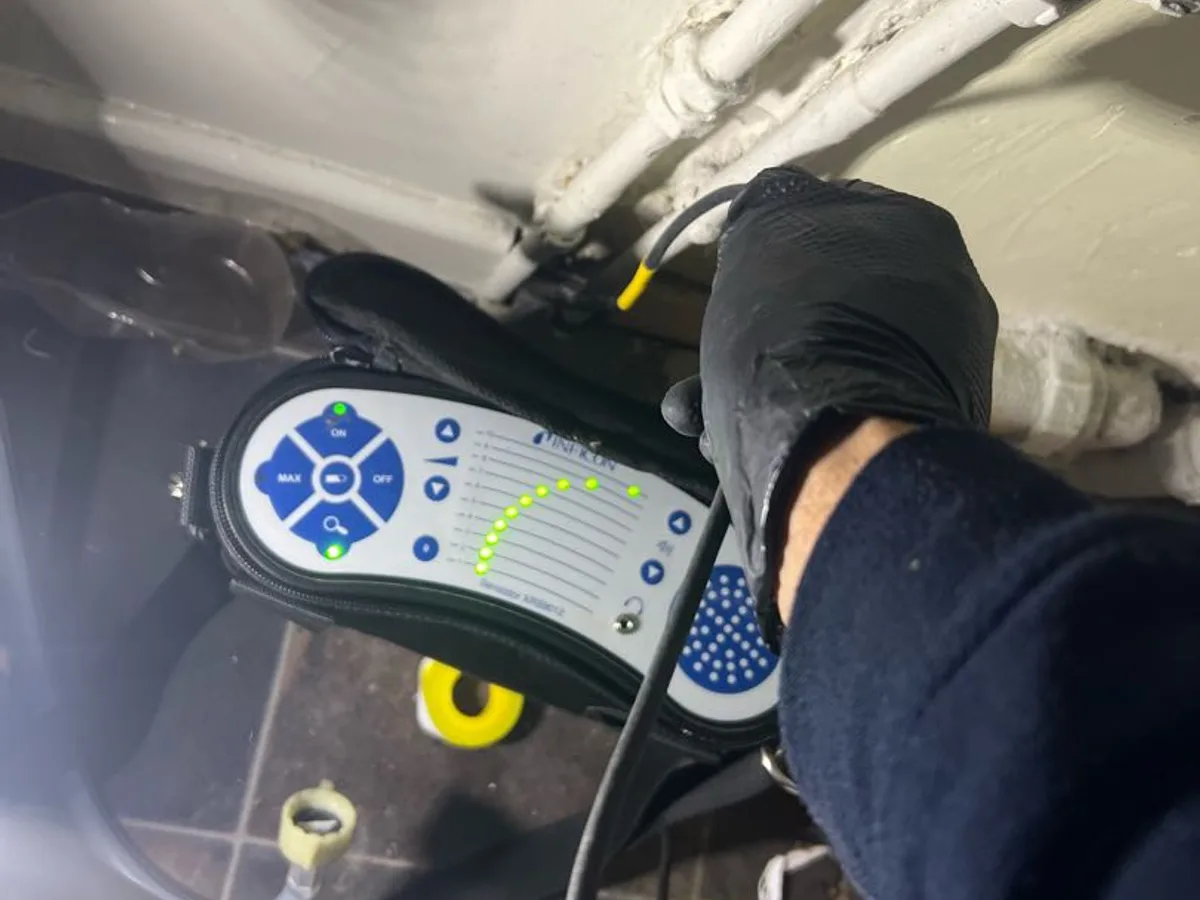 acoustic listening device held against internal pipework during leak detection investigation