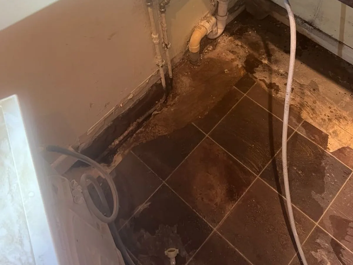 leak exposed at excavated kitchen utility floor revealing wet tiles and damaged buried pipework — leak located at