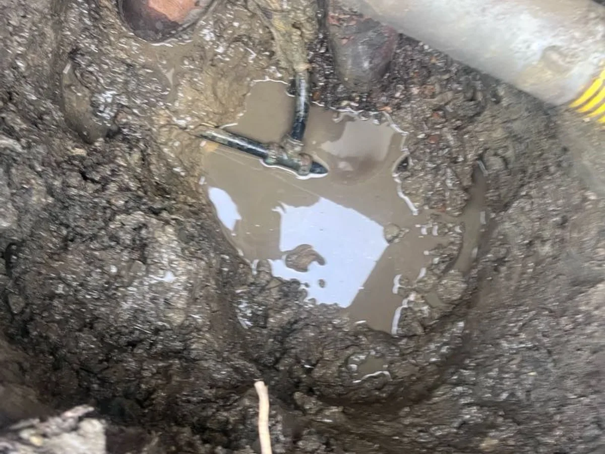 leak located at pooling water in excavation pit around faulty brass compression fitting on underground mains