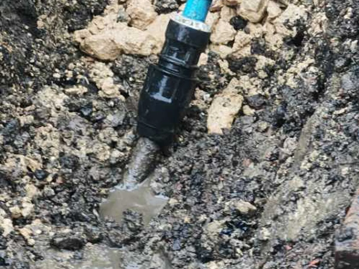 damaged lead supply pipe capped off with transition coupler as repair completed in excavation